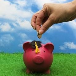 Person putting coins in piggy bank saving for tuition fees